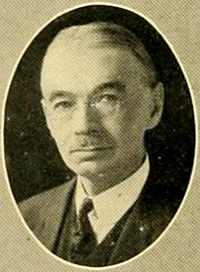 William Henry Glasson. He has short hair and glasses. A thin moustache also.