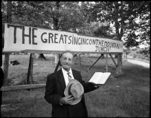 Joe L. Hartley Sr. in front of the Singing on the Mountain sign
